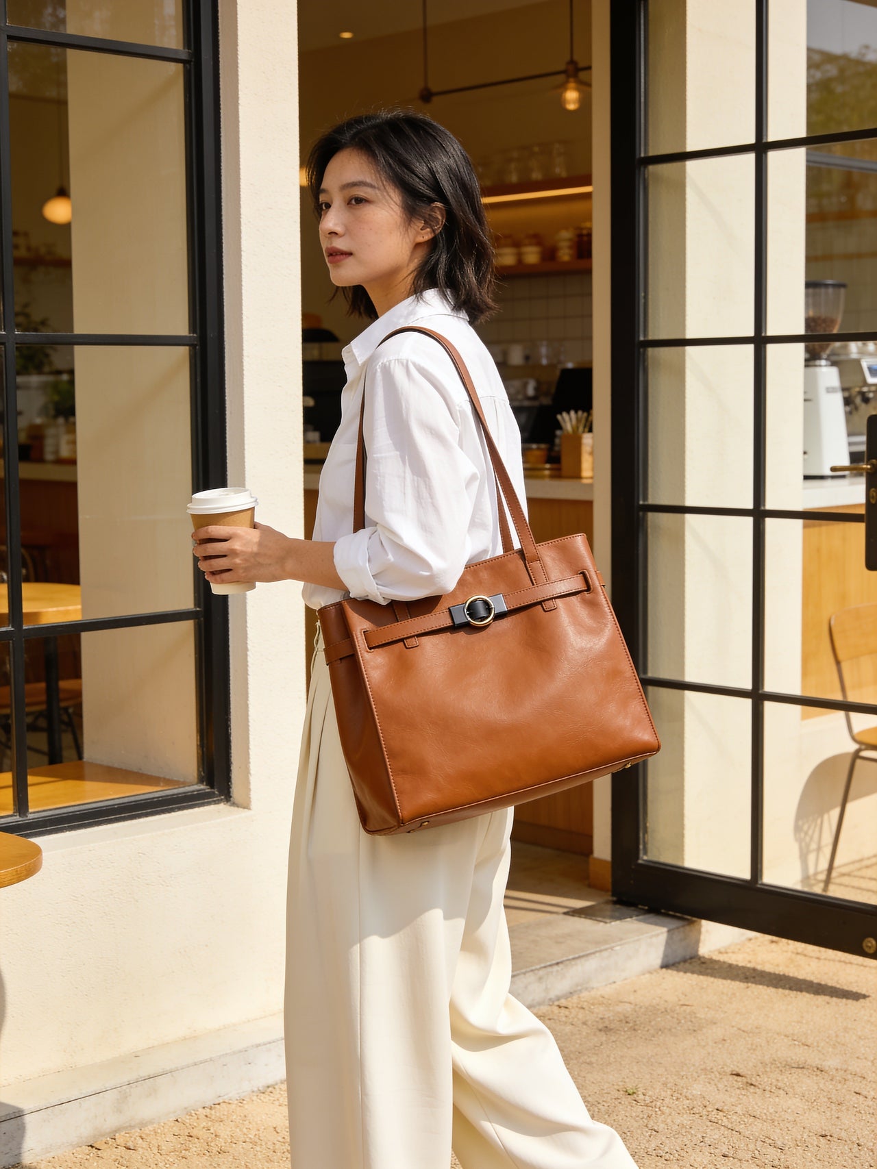 Caramel leather tote carried at a cafe